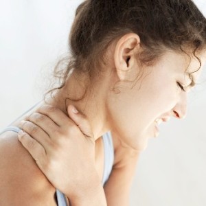 Young Woman Holding Her Neck in Pain --- Image by © Royalty-Free/Corbis